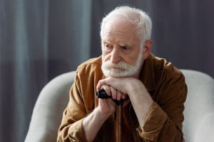 senior lonely man looking away while sitting