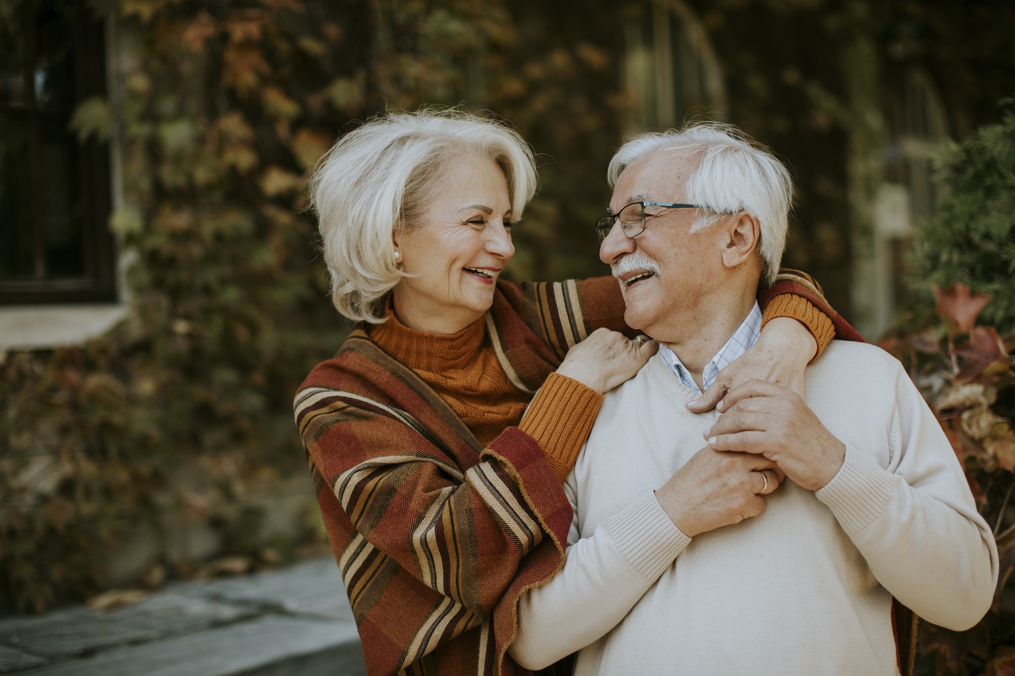 Senior couple embracing in a park during autumn