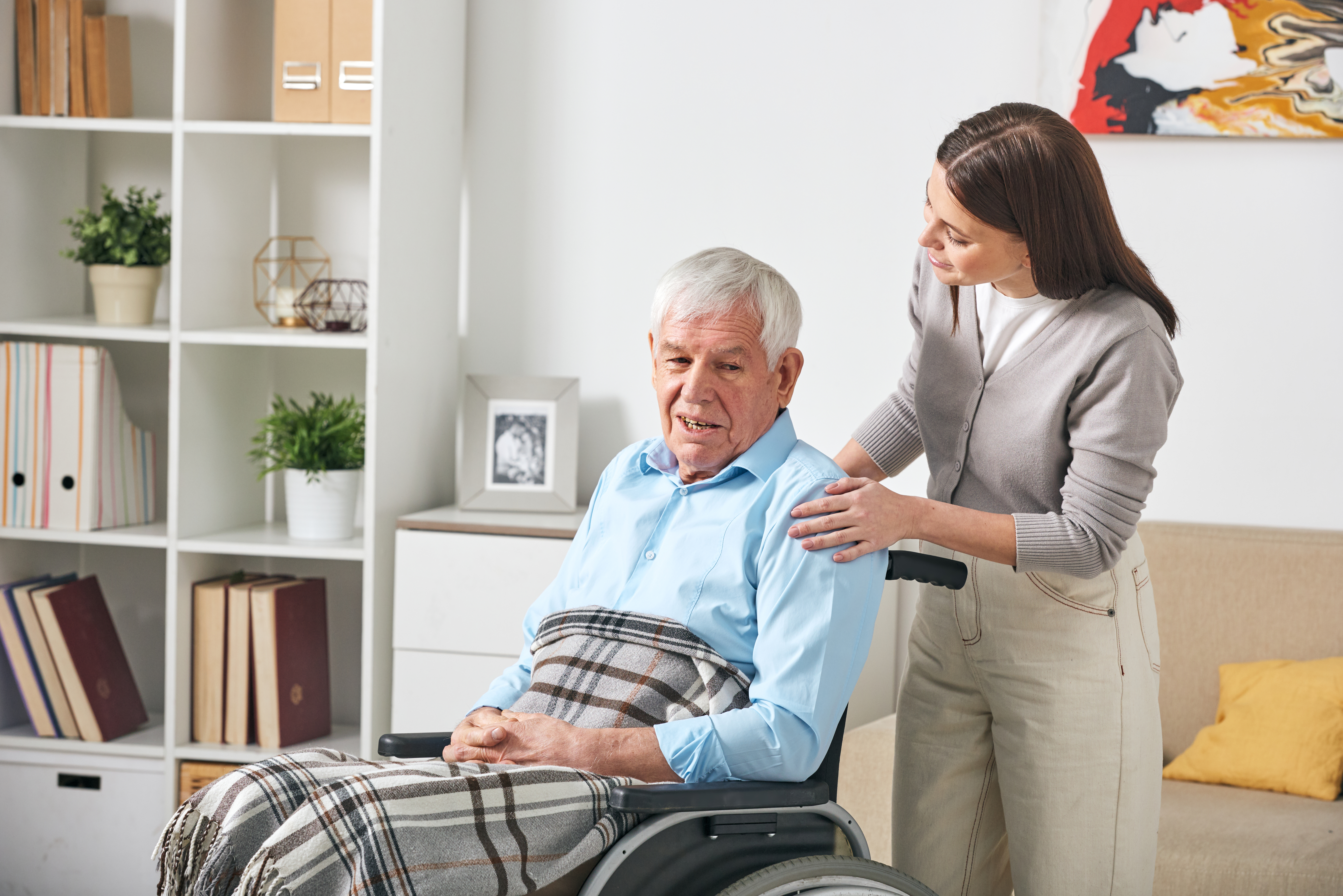 Woman talking to an elderly man in a wheelchair
